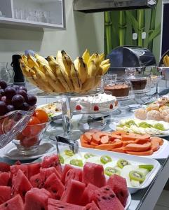 un buffet de comida con frutas y verduras en una mesa en Hotel Sabrina en Guanambi