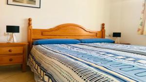 a bedroom with a wooden bed with blue pillows at Welooveyou Bahia Sunlight in Costa Calma