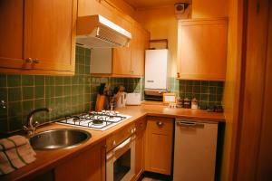 cocina con fregadero y fogones horno superior en Edinburgh Backpackers, en Edimburgo