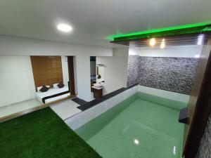 Habitación con piscina y dormitorio con cama en Hotel Jurkis, Kolhapur, en Kolhapur