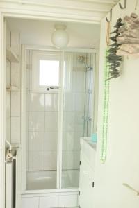 een witte badkamer met een douche en een wastafel bij Strand-chalet Luna - 700 mtr van het strand van Ouddorp in Ouddorp