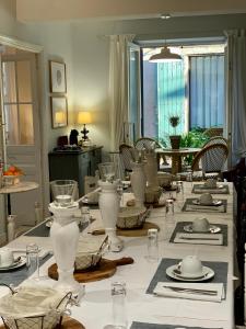 un comedor con una mesa con jarrones blancos. en L'Ancienne Boulangerie, en Caunes-Minervois