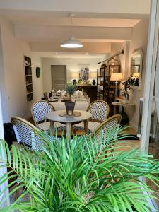 a dining room with a table and chairs and plants at L'Ancienne Boulangerie in Caunes-Minervois