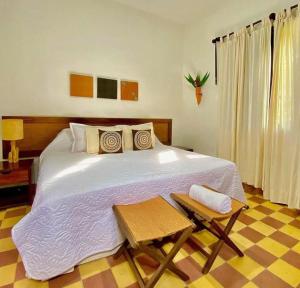 ロス・サントスにあるHotel Hacienda El Robleのベッドルーム(大きな白いベッド1台、テーブル付)