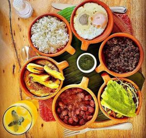 a table with bowls of different types of food at Hotel Hacienda El Roble in Los Santos