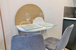 einen Tisch mit zwei Weingläsern und einem Stuhl in der Unterkunft The cozy nest #CT in Grenoble