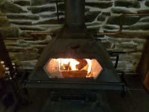 Un horno de ladrillo con fuego. en The Annex, Kilbride Farmhouse, en Dunoon