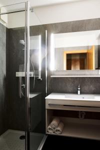 ein Bad mit einem Waschbecken und einer Dusche in der Unterkunft Hotel Garni Thermenoase in Bad Blumau