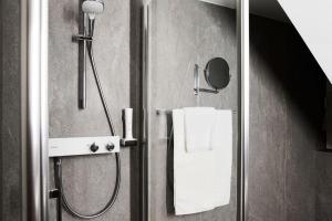 ein Bad mit einer Dusche und einer Glastür in der Unterkunft Hotel Garni Thermenoase in Bad Blumau