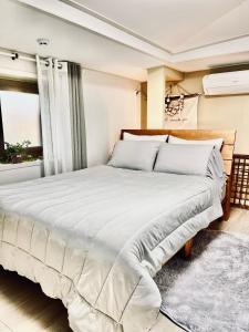 a bedroom with a large bed with white sheets at Jeju Time in Jeju