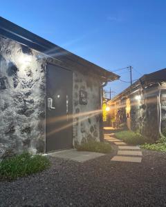 eine Tür an der Seite eines Gebäudes in der Nacht in der Unterkunft Jeju Time in Jeju-do