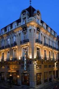un grand bâtiment avec un panneau devant lui dans l'établissement Hotel Luxembourg, à Thessalonique