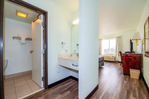 un bagno con lavandino e specchio di Rodeway Inn Central Colorado Springs a Colorado Springs Altre 37 foto