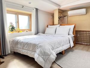 1 dormitorio con cama y ventana en Jeju Time en Jeju