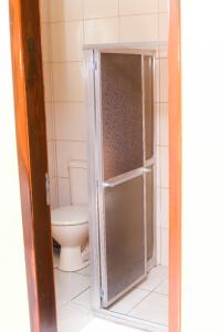 Łazienka z toaletą i szklanymi drzwiami prysznicowymi w obiekcie Hotel Luma w mieście Itaguaí