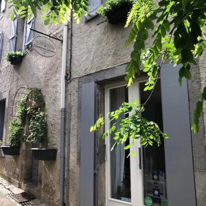 un edificio con una puerta blanca y una ventana en L'Ancienne Boulangerie, en Caunes-Minervois