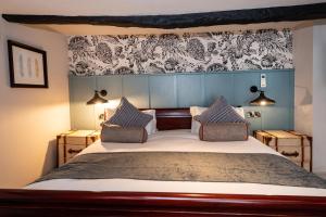 ein Schlafzimmer mit einem großen Bett mit zwei Kissen in der Unterkunft Greswolde Arms by Chef & Brewer Collection in Solihull