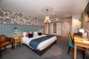 a hotel room with a large bed and a desk at Greswolde Arms by Chef & Brewer Collection in Solihull