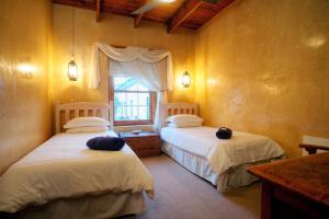 a bedroom with two beds and a window at Finchley Farm Cottages in Willowmore +38 photos