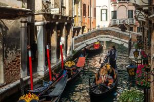 um grupo de gôndolas em um canal em uma cidade em Al Gazzettino em Veneza