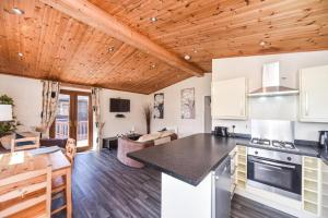a kitchen and living room with wooden ceilings at #2 Delightful 3 bedroom holiday lodge no hot tub 