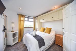 a bedroom with a white bed and a window at #2 Delightful 3 bedroom holiday lodge no hot tub 