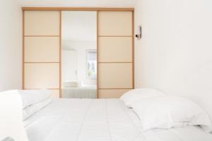 2 Betten in einem Schlafzimmer mit Glastüren in der Unterkunft Maison de bourg a deux pas de la mer in Saint-Brevin-les-Pins