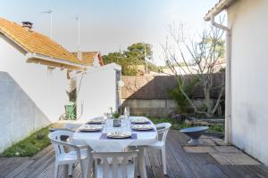 a white table and chairs on a wooden deck at Maison de bourg à deux pas de la mer in Saint-Brevin-les-Pins