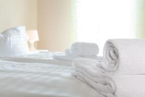 een slaapkamer met witte lakens en handdoeken op een bed bij Meerferienhaus - Wellnesshaus Zinnowitz in Zinnowitz