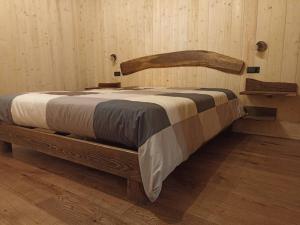 a wooden bed with a wooden headboard in a room at Ca' de Baci' du Mattu in Mendatica