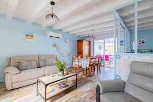 sala de estar con sofá y mesa en Villa moderne et coloree a Jard sur mer, en Jard-sur-Mer