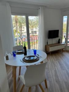 mesa de comedor blanca con sillas y TV en Apartamento Esperanza by Altea Blanca Apartamentos Turísticos en Altea