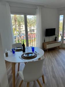 une table à manger blanche avec des chaises et une télévision dans l'établissement Apartamento Esperanza by Altea Blanca Apartamentos Turísticos, à Altea