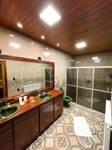 a large bathroom with two sinks and a shower at Pousada Caminhos Da Neve in São Joaquim