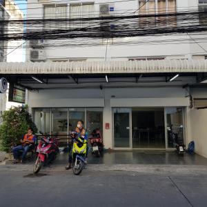 duas motos estacionadas em frente a um edifício em Checkin Hostel @DonMuang Airport em Bangkok