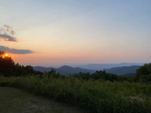 a sunset on a hill with a view of the mountains at Shenandoah Getaway Near National Park Cozy Space! in Shenandoah