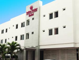 a white building with a red sign on it at Hotel Suites Gaby in Cancún
