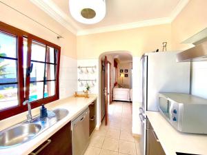 eine Küche mit einer Spüle und einem Kühlschrank in der Unterkunft Villa Ágatha, vacaciones en familia en Lanzarote in Playa Blanca