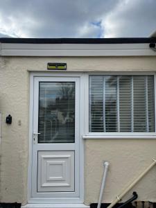 a house with a white door and a window at Beach retreat in Prestatyn