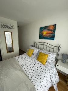a bedroom with a large bed with yellow pillows at Beach retreat in Prestatyn