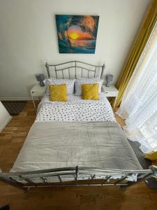 a bedroom with a bed with two yellow pillows at Beach retreat in Prestatyn