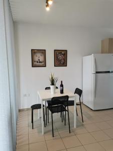 La cuisine est équipée d'une table et de chaises blanches. dans l'établissement City Flats 308, à Larnaka