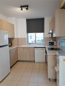 a kitchen with a white refrigerator and a window at City Flats 308 in Larnaca