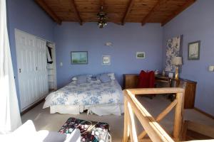 Un dormitorio con paredes azules y una cama y una mesa. en Departamento Costanera, en San Carlos de Bariloche
