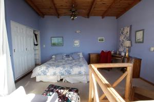 1 dormitorio con paredes azules, 1 cama y 1 mesa en Departamento Costanera en San Carlos de Bariloche