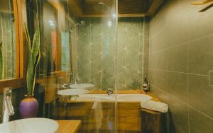 een badkamer met een bad en een wastafel bij The Wooden Gate in Xuân Sơn