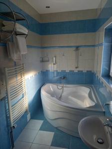 Penzion starojicka pizza في Starý Jičín: حمام مع حوض استحمام أبيض ومغسلة