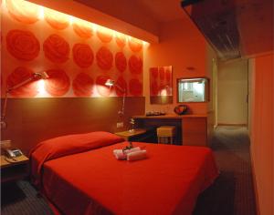 Habitación de hotel con cama roja y escritorio. en Palladion Boutique Hotel, en Argos