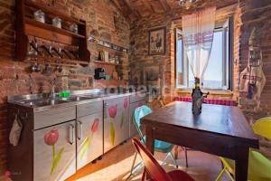 een keuken met een houten tafel en een wastafel bij NIDO SCANSANESE in Scansano