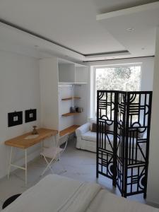 a room with a bed and a desk and a table at Mare Monte Small Boutique Hotel in Chrysi Ammoudia
